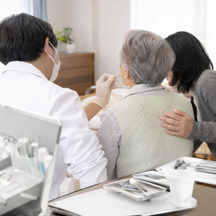 歯科医が高齢の方のお口を直接診ている様子